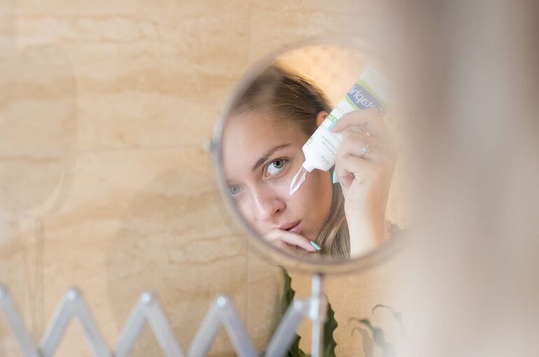 person-moisturize-lotion-bathroom